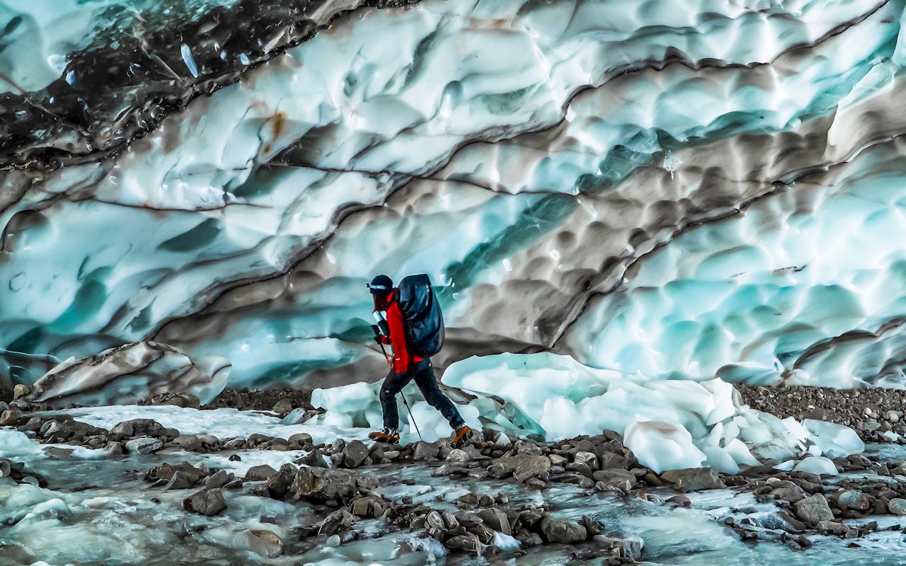 Services A lone hiker treks through a stunning glacier landscape in Yunnan, China, capturing nature's beauty.
